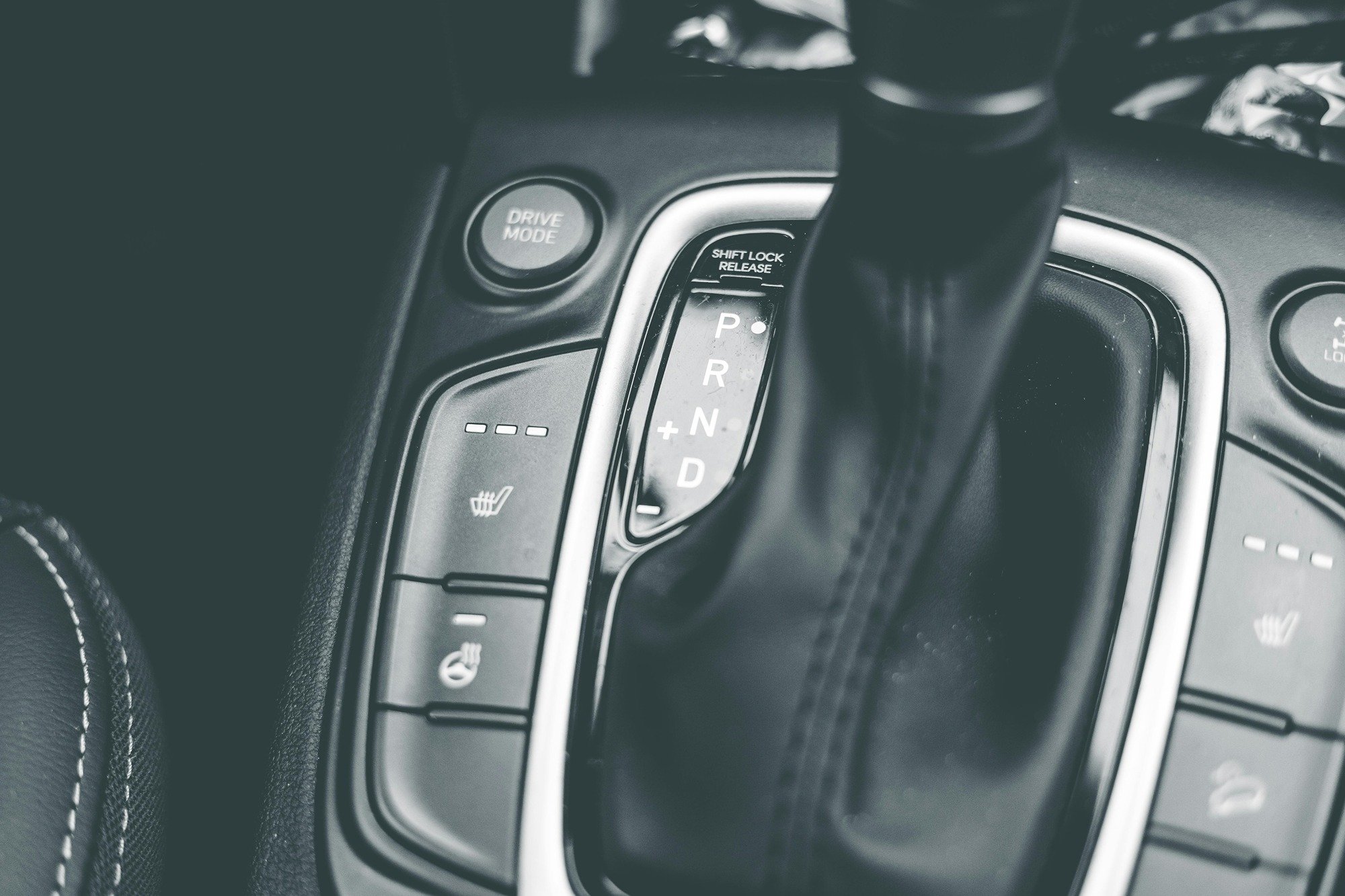 Close-up of a car's automatic gear shift and drive mode button